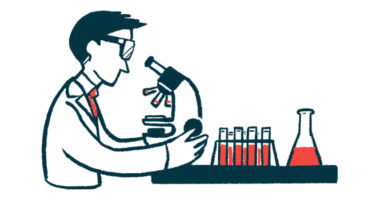 A clinical researcher uses a microscope to examine vials of fluid.