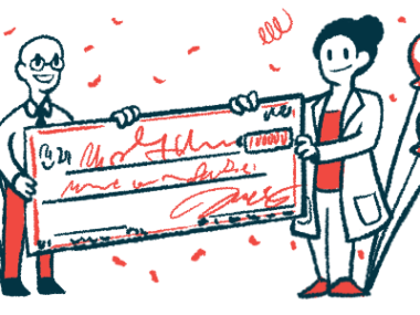 A researcher is presented with a giant check that's framed by balloons and confetti.