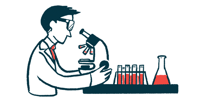 A scientist looks in a microscope in a lab alongside a rack of vials and a beaker filled with blood.