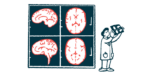 A researcher examines brain images, which are displayed larger behind him.