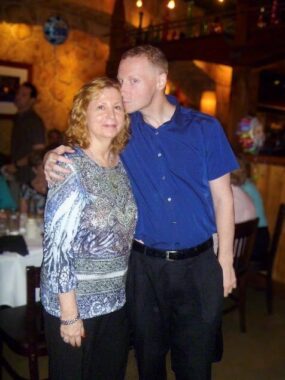 George Ackerman wraps his arm around the shoulder of his mother, Sharon, and plants a kiss on her forehead.